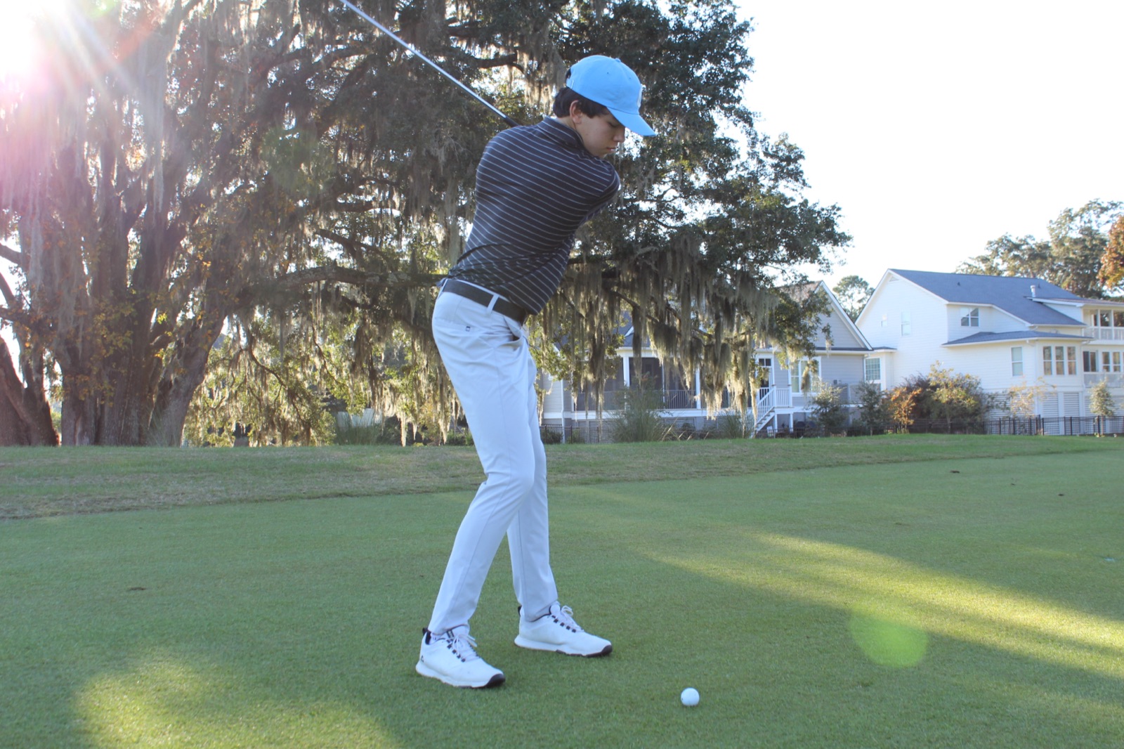 Cooper mid-swing on a fairway